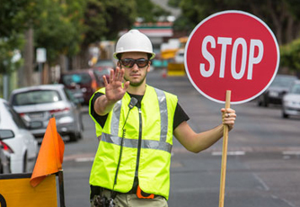 Security guard wearing a reflective vest and directing traffic